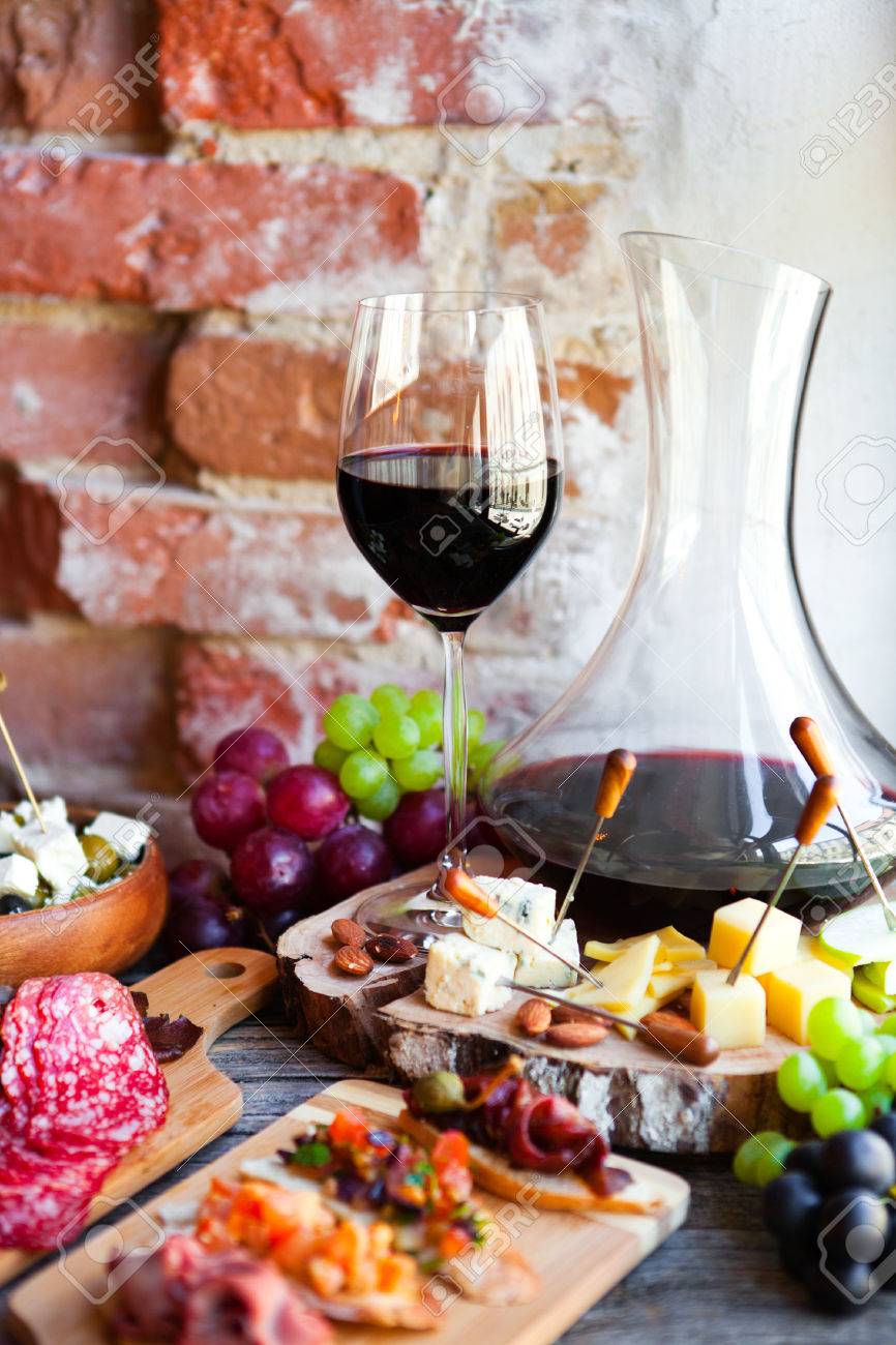 76443689-set-de-bocadillos-de-vino-vaso-de-vino-tinto-uva-queso-sobre-fondo-de-madera-rústica-...jpg