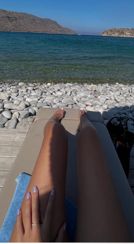 Las piernas de Sarah Santaolalla tomando el sol en la orilla.jpg