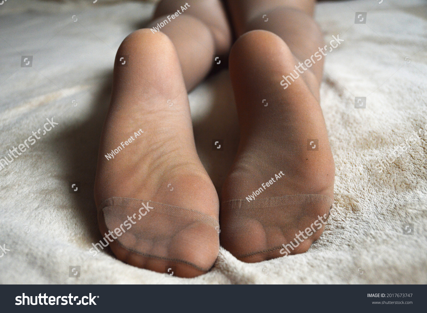 stock-photo-women-s-soles-and-toes-in-pantyhose-lying-on-a-blanket-on-the-bed-2017673747.jpg